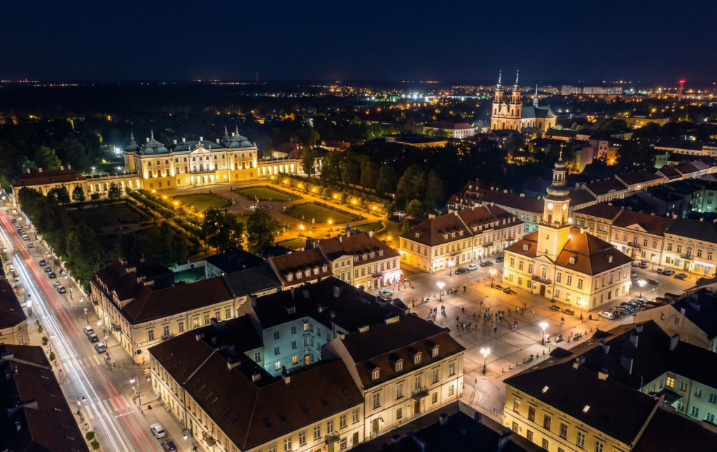 Nocna panorama centrum Białegostoku z lotu ptaka, widoczny oświetlony Pałac Branickich i Rynek Kościuszki – obsługa social media Białystok